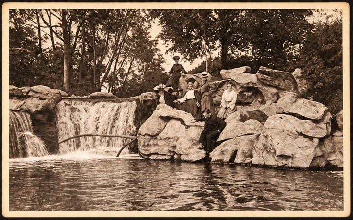 Postcard No. 11 — guests on the rocks by the park waterfall, sepia