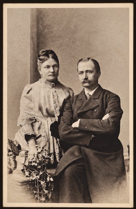 Postcard No. 30 — a couple in a photo studio: a lady in a lace dress and a gentleman with a moustache and folded arms, portrait, sepia