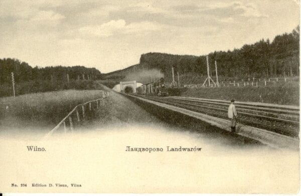 Sepia postcard showing railway tracks leading to a tunnel portal, a man standing on the platform