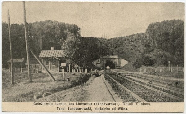 Vintage postcard showing railway tracks leading to an arched tunnel portal beside a small trackside building